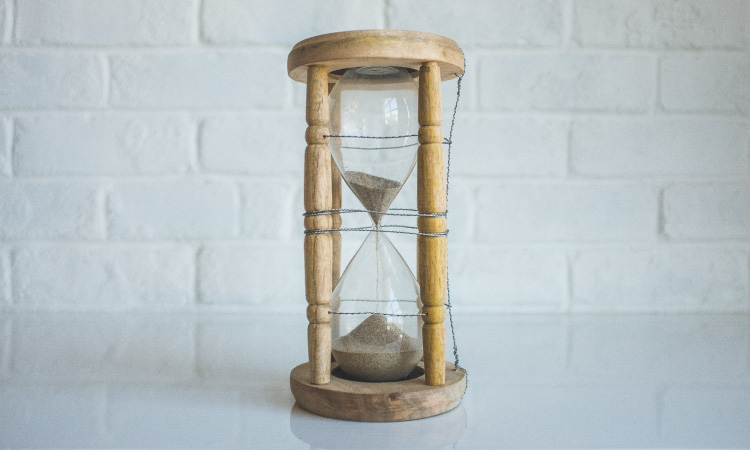 Brown hourglass with sand flowing down to measure time