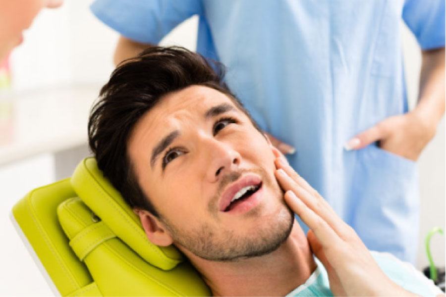 young man sitting in the dentist's chair ready for root canal therapy