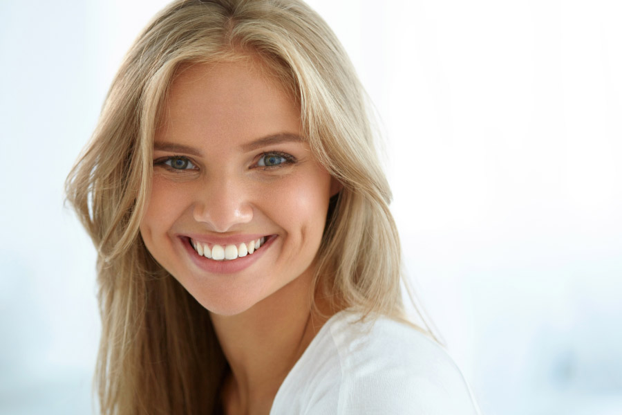young woman flashes her bright smile after cosmetic dental treatments