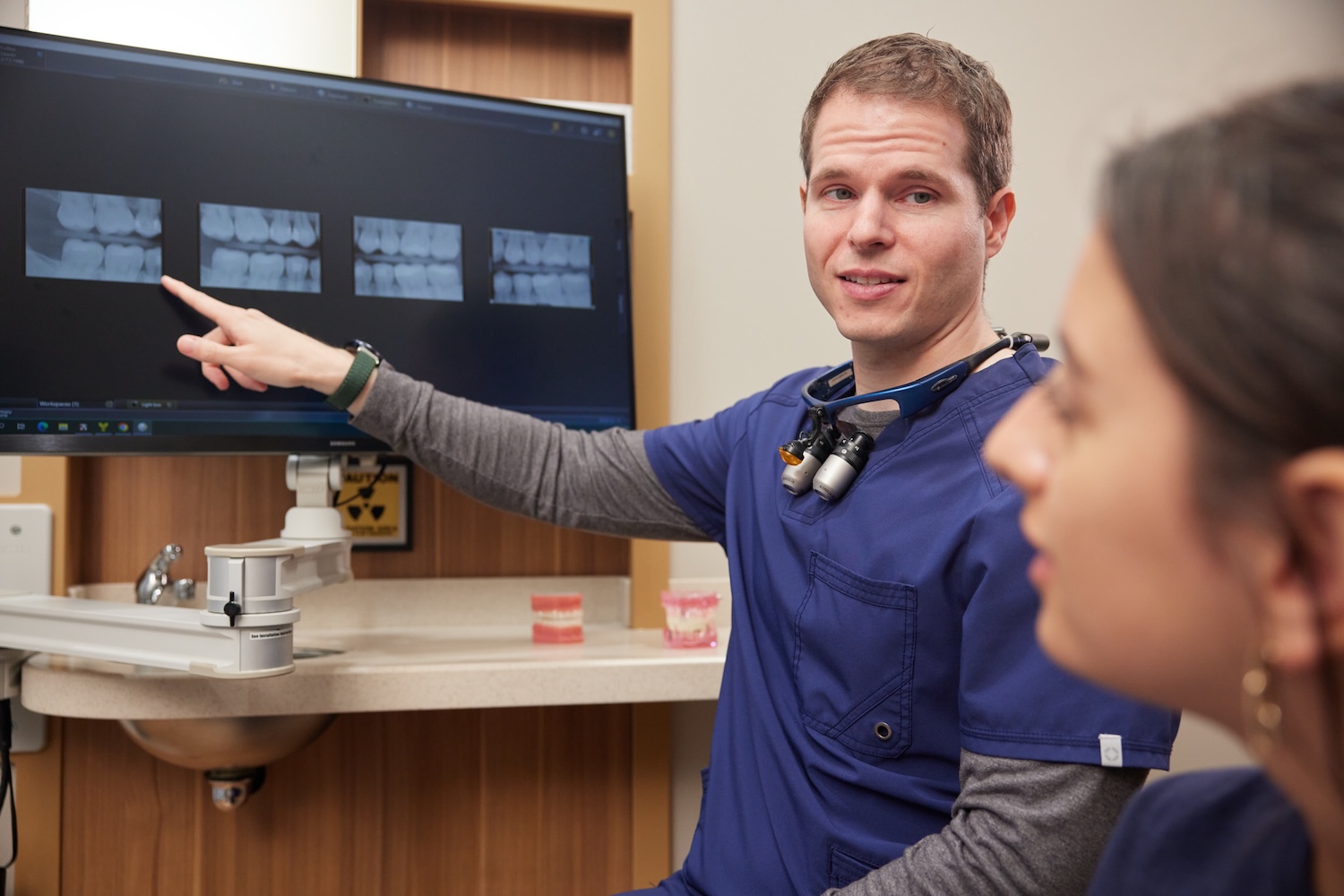 dentist showing patient routine checkup xrays, how early year dental appointments save money and use dental insurance benefits