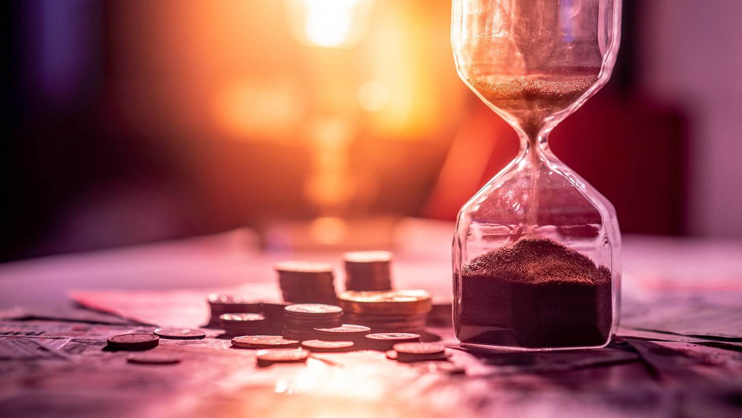 Stacks of coins next to a sand time turner to indicate expiring dental benefits from Blue Cross Blue Shield