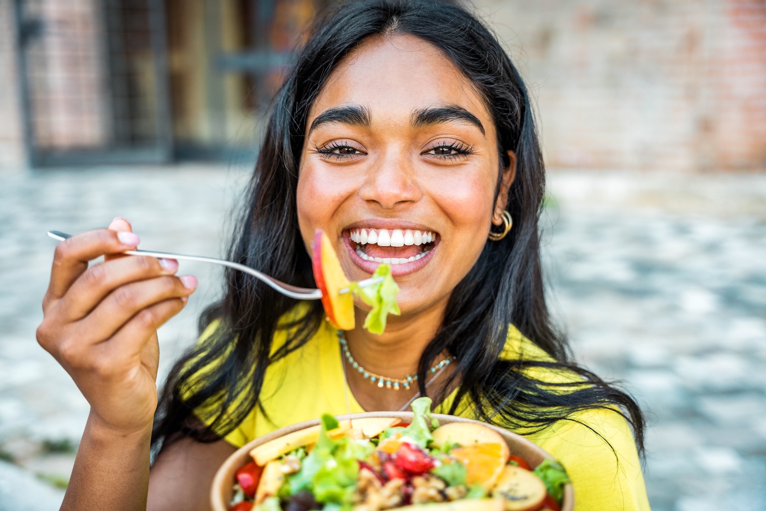 woman eatin ghealthy food for oral health during National Nutrition Month