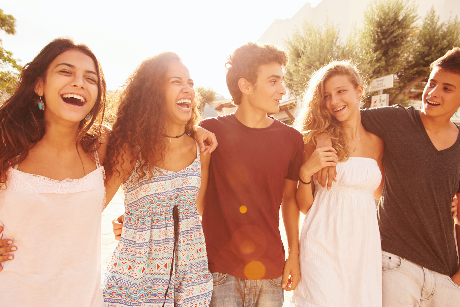 A group of teens smile as they walk together outside
