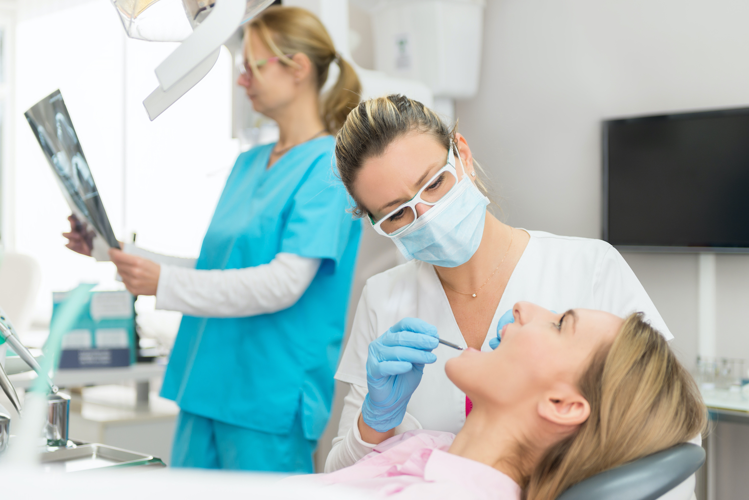 Closeup of a dentist evaluating the health of a patient's teeth and gums before teeth whitening