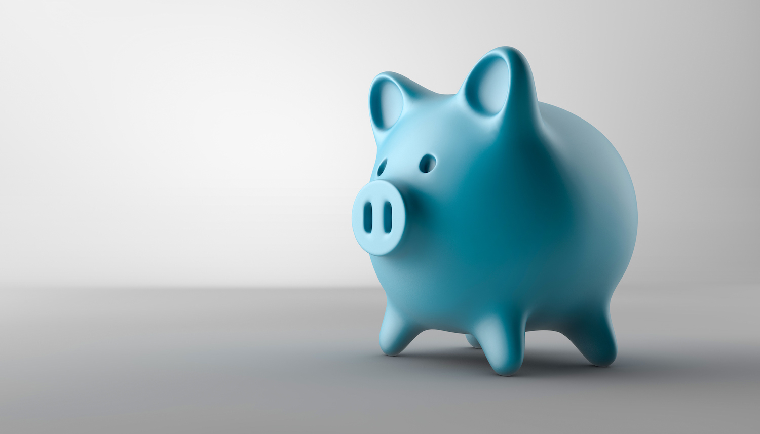 closeup of a blue piggy bank against a gray background to indicate affordable dental care