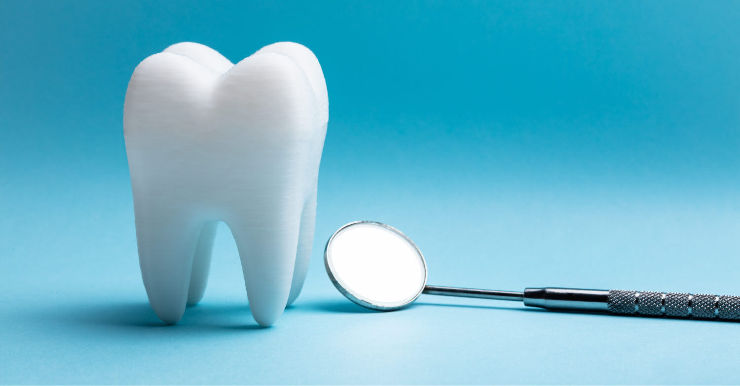 A white tooth next to a dental mirror against a blue background