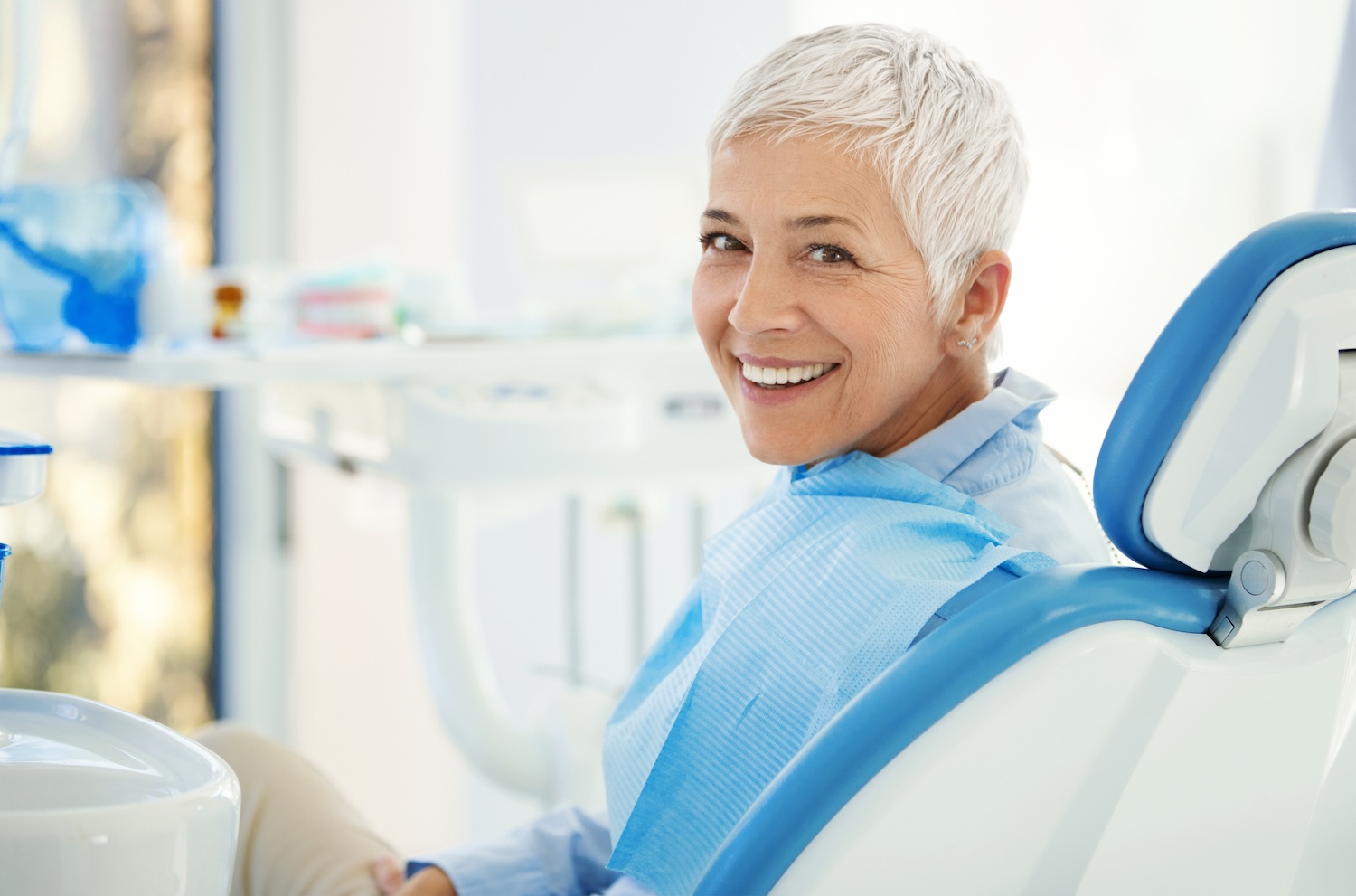woman in dental chair to discuss symptoms of dry mouth