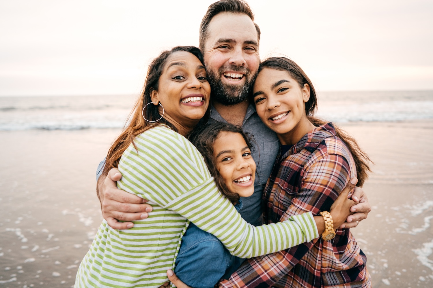 summer dental habits, smiling family on the beach in summer