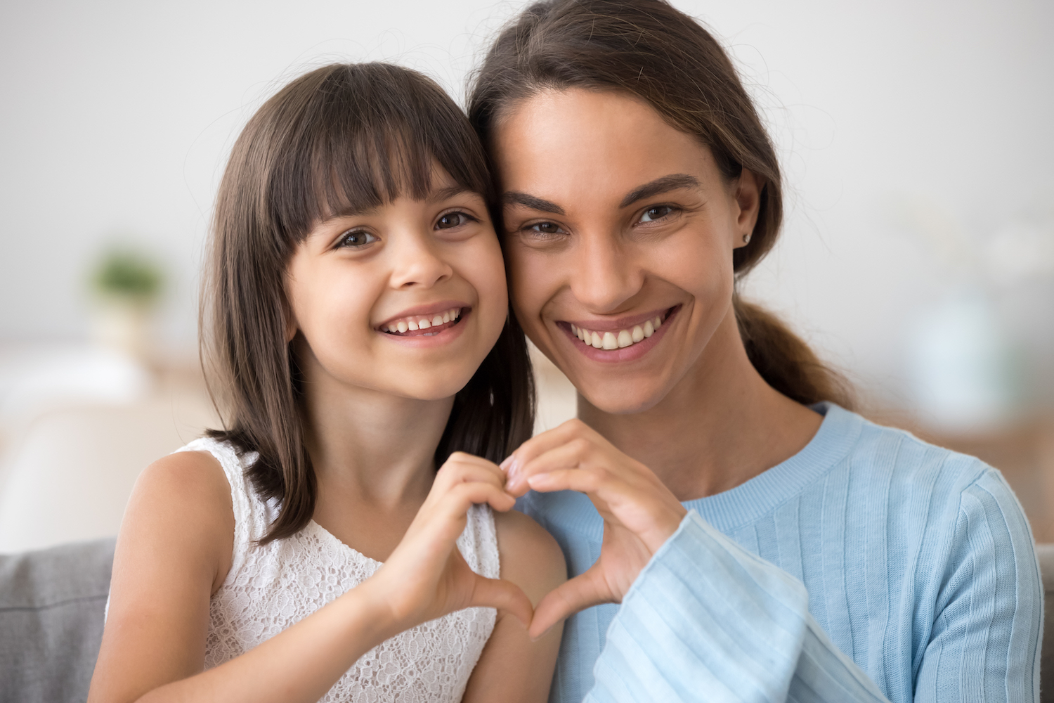 heart health, oral health, oral and heart health, Cute little daughter and happy mother join hands in shape of heart as concept of mom and child love care support, smiling mum and her kid girl looking at camera posing together for headshot portrait