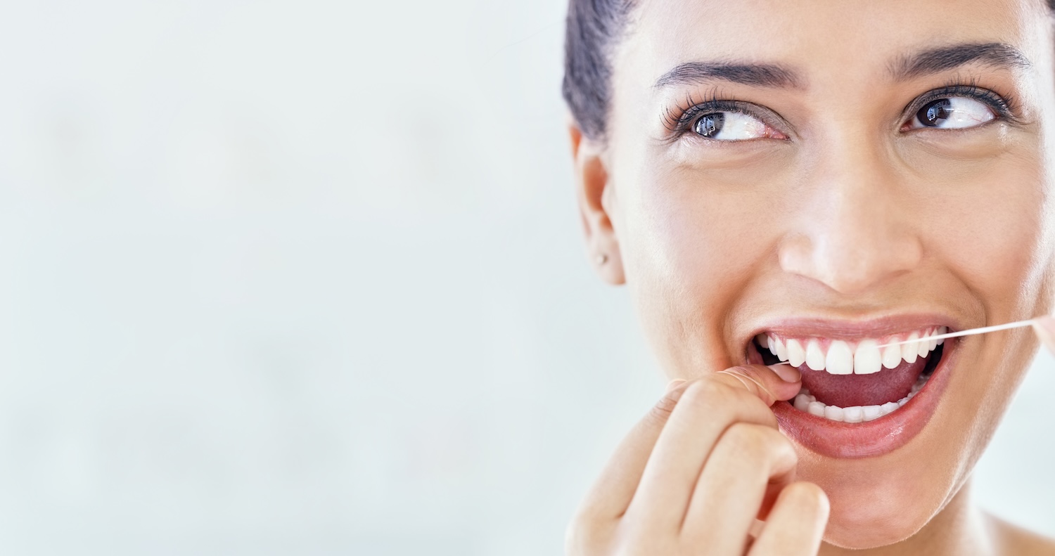 woman flossing her teeth, a great habit during national dental hygiene month