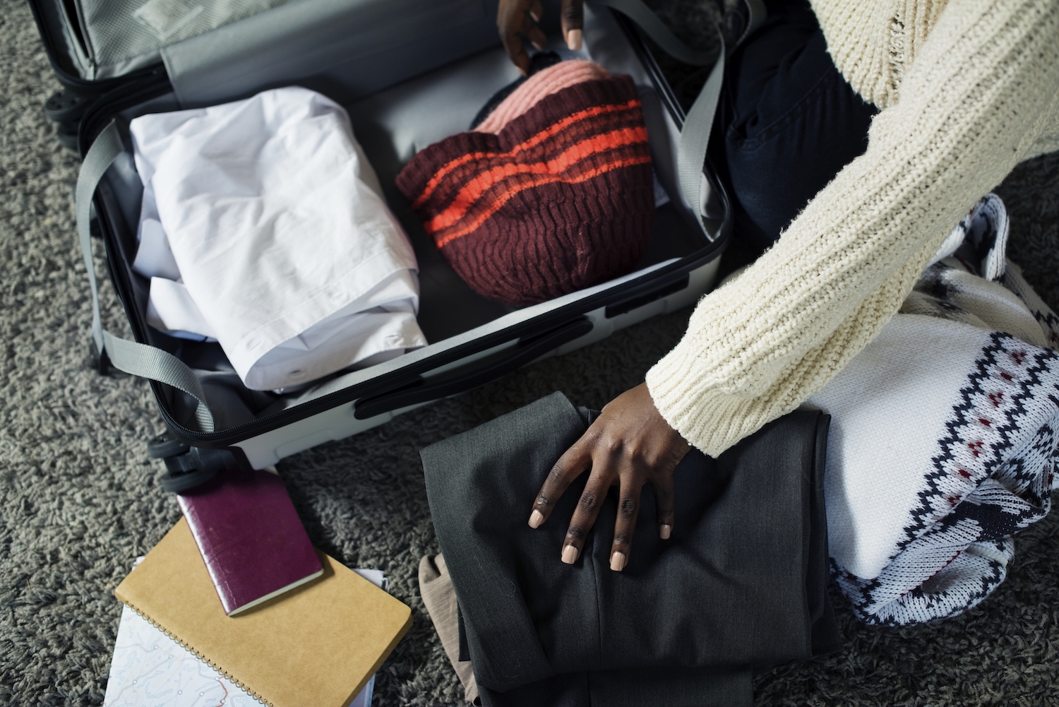 Aerial view of a Black woman packing her suitcase for her vacation